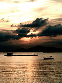 The sun rises on the shore of the sea there was also a shadow of a merchant ship and fishing boat