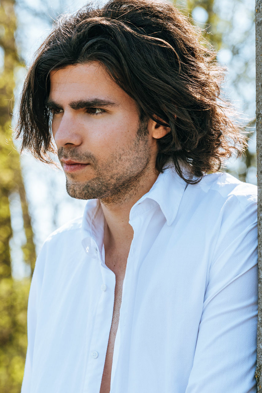 PORTRAIT OF MAN LOOKING AWAY OUTDOORS