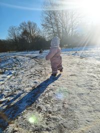 Rear view of boy on snow covered land