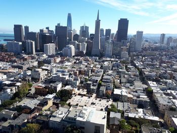 Aerial view of buildings in city against sky