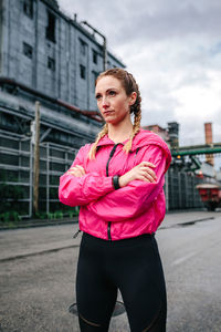 Sportswoman with boxer braids posing in front of a factory in an industrial zone