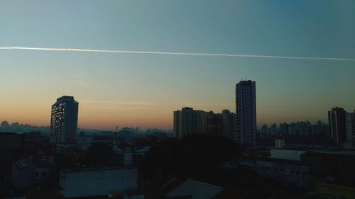 Buildings in city against sky during sunset