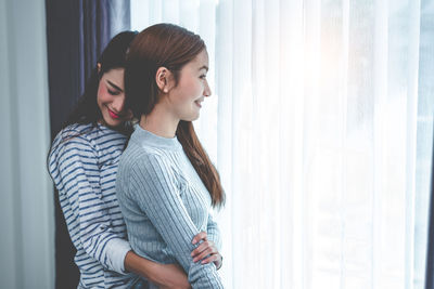 Lesbian couple embracing at home