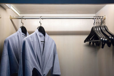 Close-up of clothes hanging on rack in shelf