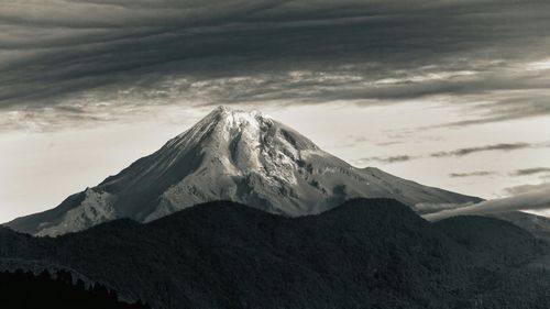 Scenic view of mountains against cloudy sky