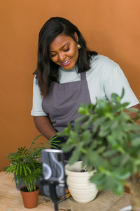 Portrait of young woman sitting on plant