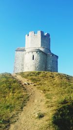 Low angle view of fort against clear blue sky