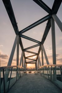 Bridge in city against sky during sunset