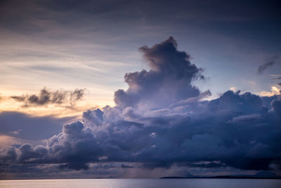 Scenic view of sea against cloudy sky during sunset