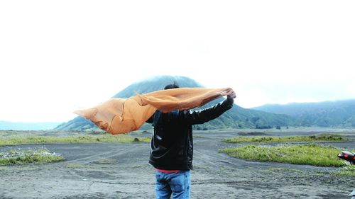 Rear view of man with scarf against mountain