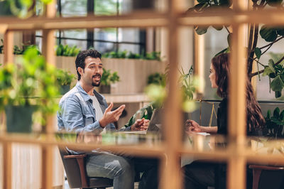 Young man sitting on table at restaurant