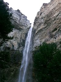 Low angle view of waterfall against sky