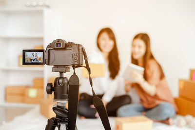 Close-up of camera photographing female coworkers in home office