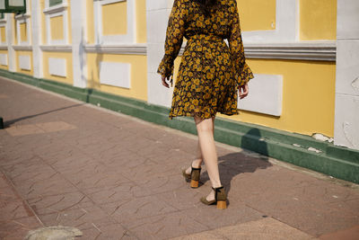 Low section of woman walking on street