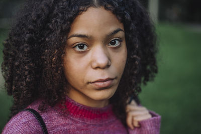 Portrait of serious teenage girl with curly hair