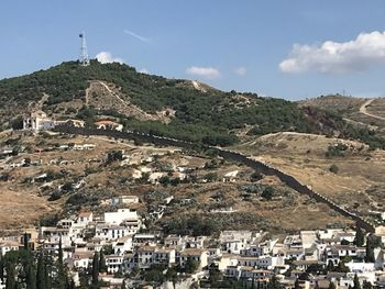 Aerial view of townscape and mountain against sky