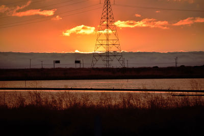 Electricity pylon against sky during sunset