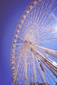 Low angle view of ferris wheel against blue sky