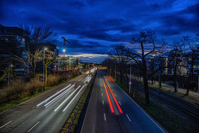 Light trails on road against sky in city
