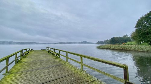 Pier over lake against sky