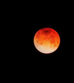 Low angle view of orange moon against sky at night