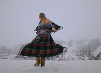 Woman dancing on snow covered land