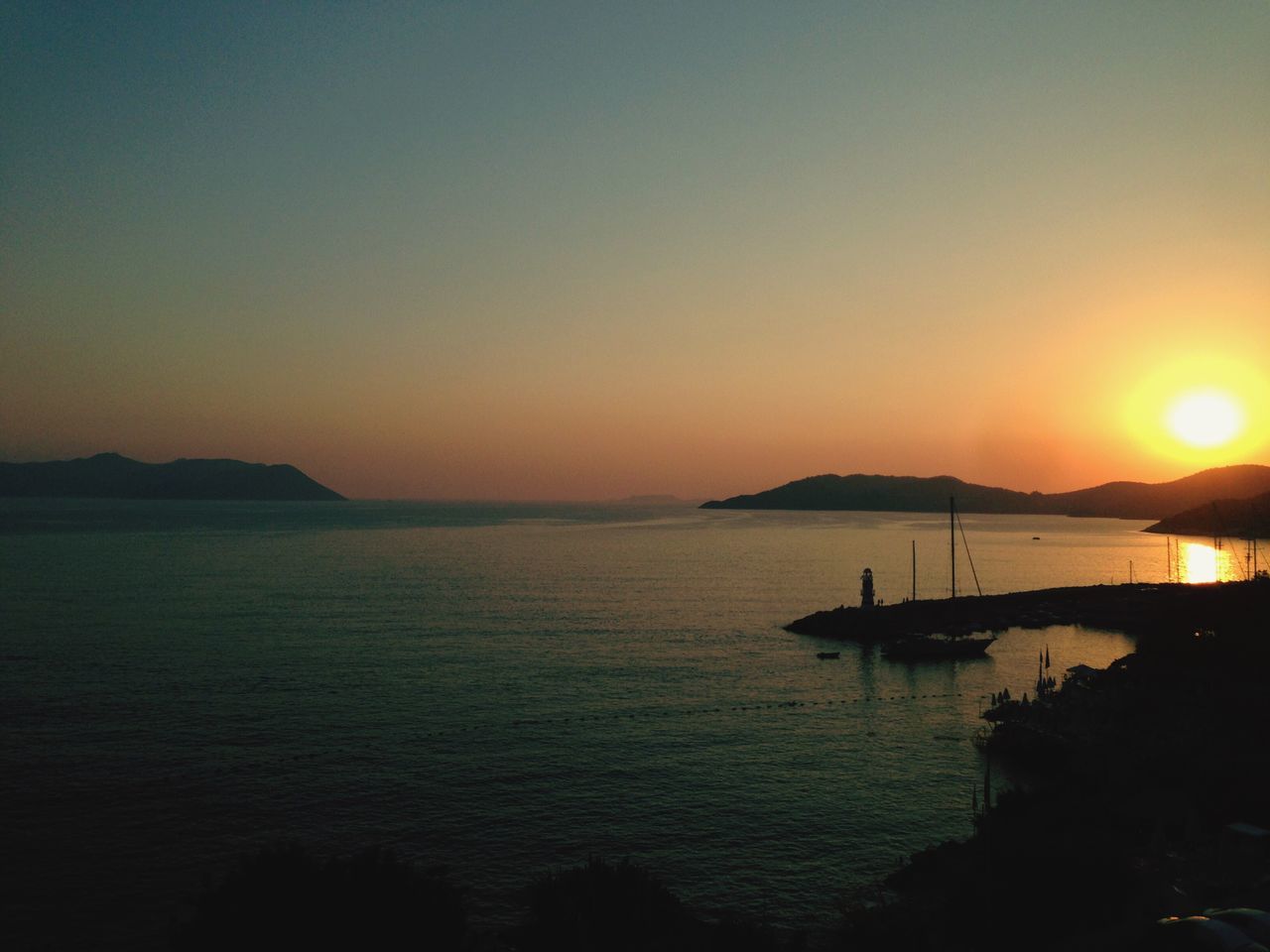 sunset, water, sun, sea, scenics, tranquil scene, beauty in nature, tranquility, orange color, silhouette, nature, copy space, idyllic, clear sky, mountain, nautical vessel, sunlight, horizon over water, sky, outdoors