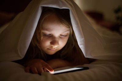 Girl using mobile phone in bed