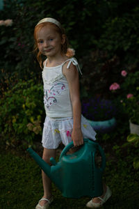 Portrait of cute girl standing against plants