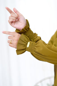 Cropped hand of woman gesturing against white background, hijab and abaya with long sleeves