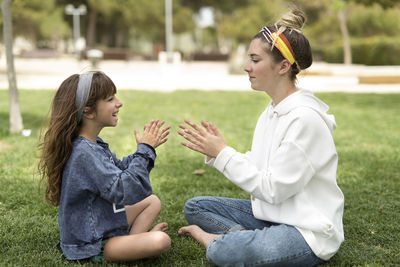 Full length of siblings playing on field at park