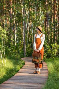 Woman botanist with backpack on ecological hiking trail. naturalist exploring wildlife, ecotourism 