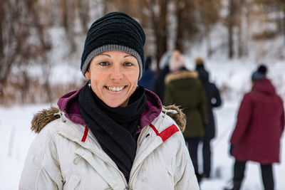 Portrait of smiling woman standing outdoors during winter