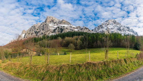Scenic view of field and mountains against sky