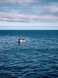 Boat sailing in sea against sky