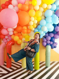 High angle view of woman standing on multi colored balloons