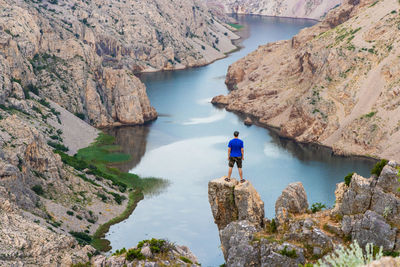 Man is standing on the cliff above the canyon of the zrmanja river, croatia