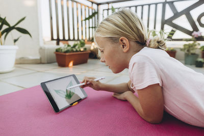 Girl drawing leaf on a tablet with digitized pen