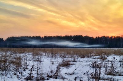 Scenic view of snow covered landscape against sky during sunset