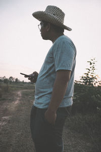 Low section of man standing on field against sky