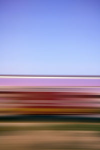 Blurred motion of light trails against clear blue sky