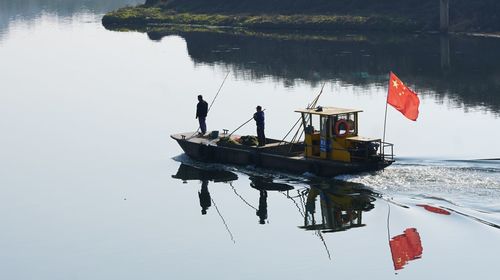 People on boat in sea against sky