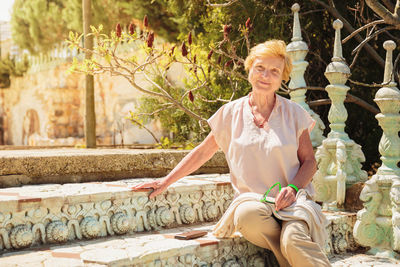 Mature woman traveler sitting on the steps of park in bulgaria