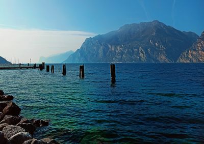 Scenic view of sea and mountains against blue sky