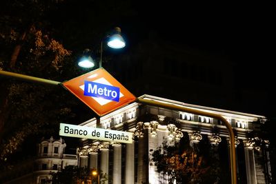 Low angle view of road sign at night