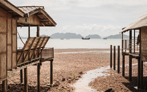 Wooden posts on beach against sky