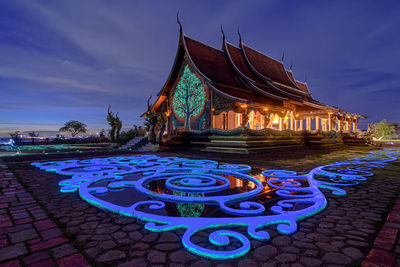 Illuminated traditional building against sky at night