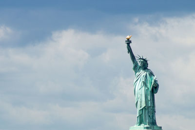 Statue of liberty against cloudy sky