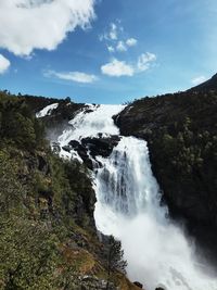 Scenic view of waterfall against sky