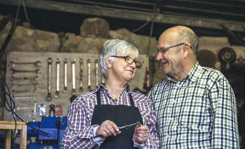 Man with arms raised standing against wall